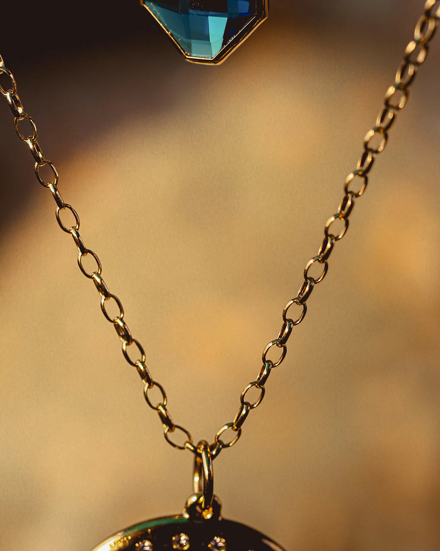 Gold pendant necklace with a blue stone — detail