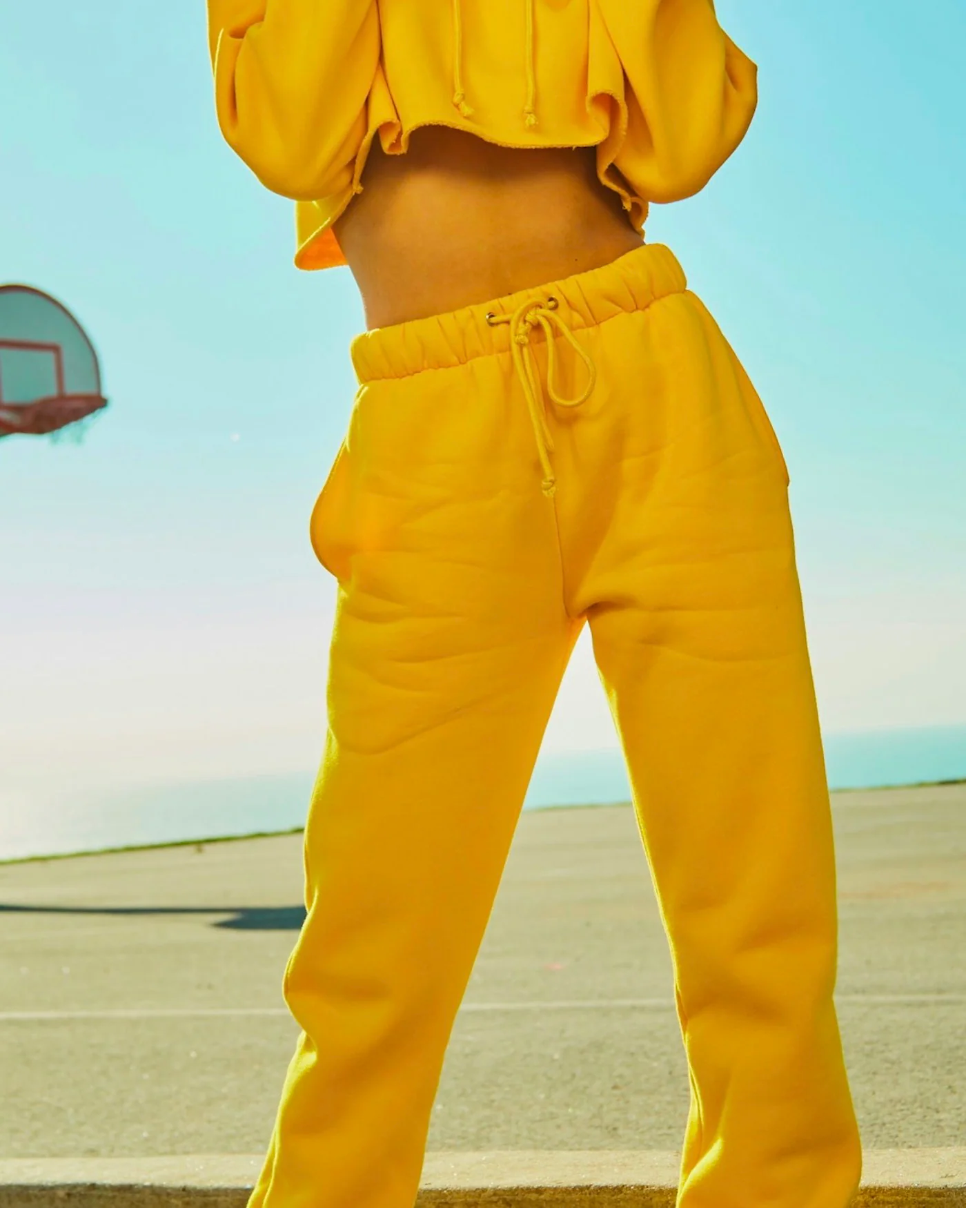 Woman wearing a yellow hoodie and jogger tracksuit set — detail