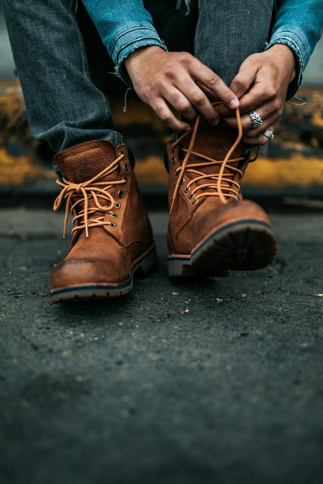Person lacing brown leather work boots
