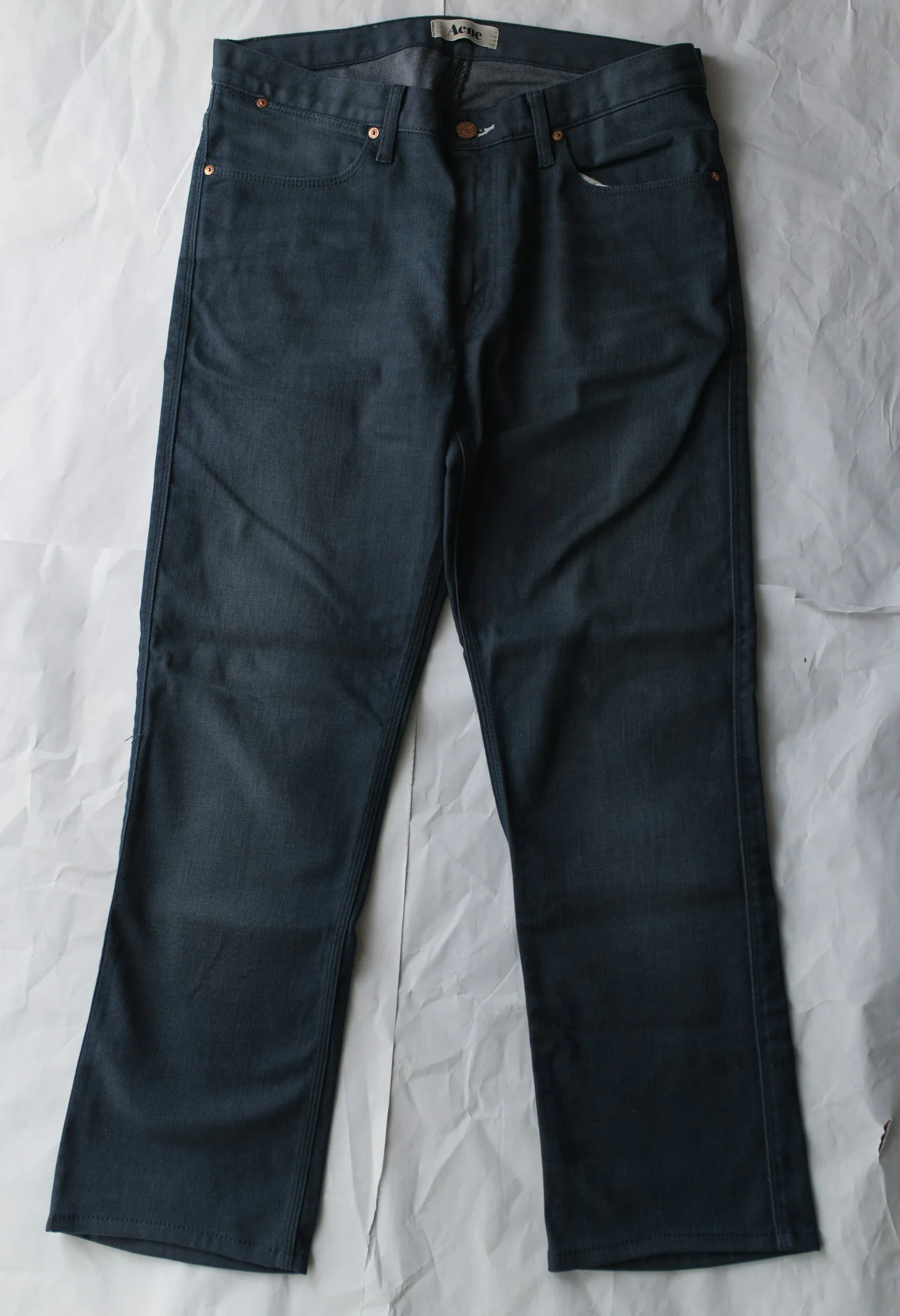 Dark raw denim jeans laid flat